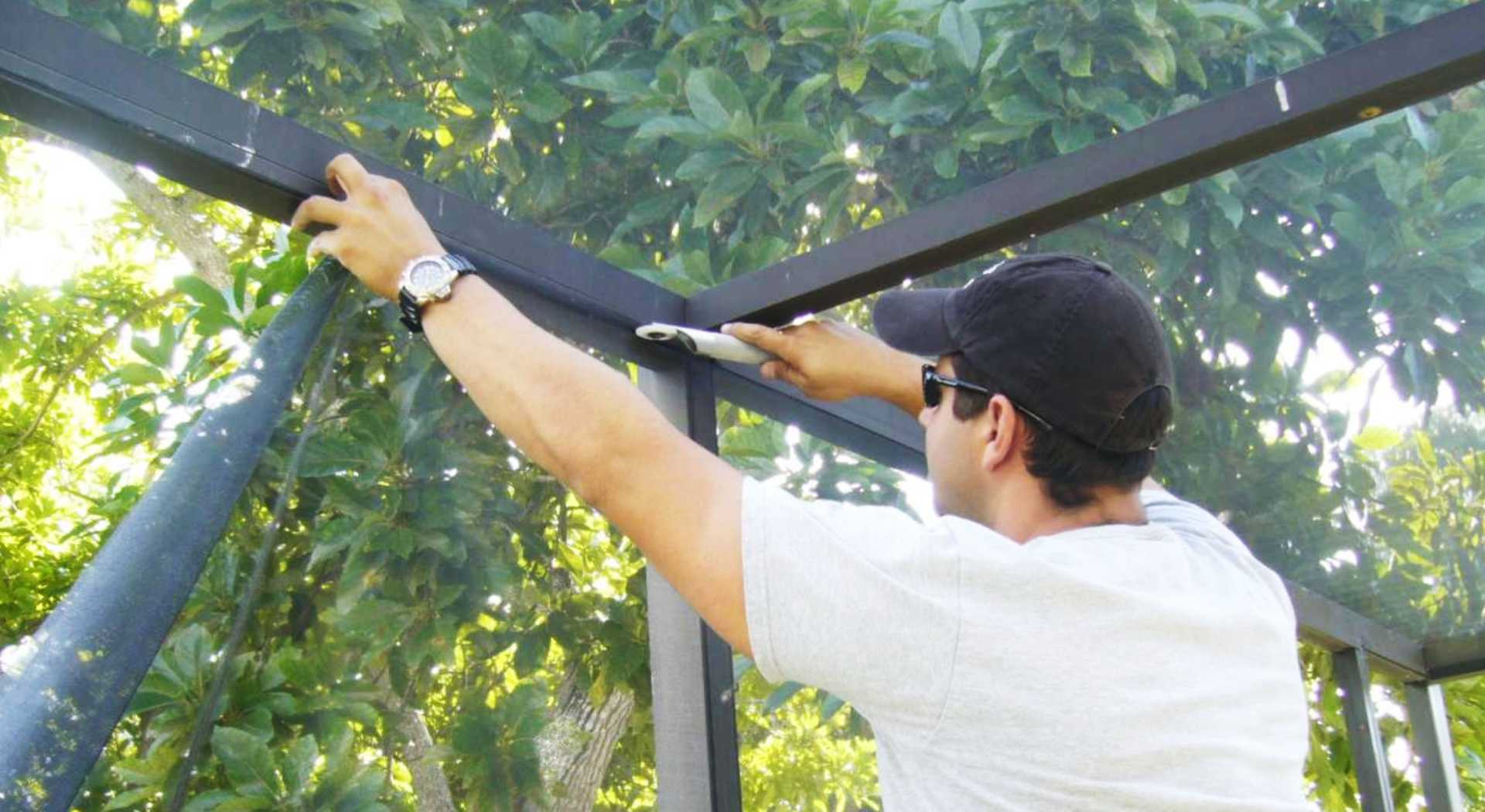 Worker Fixing the Roof Glass in Garden Area